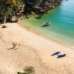 An aerial view of a secluded beach with golden sand and turquoise water