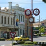 A yellow taxi navigating a roundabout in a historic town centre
