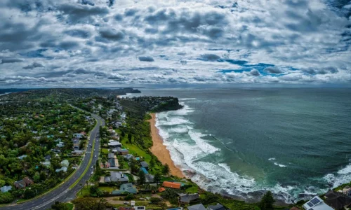 An aerial panorama of a winding coastal highway hugging a lush