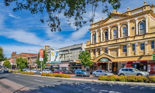A view of a sunny city street lined with historic multi-storey buildings